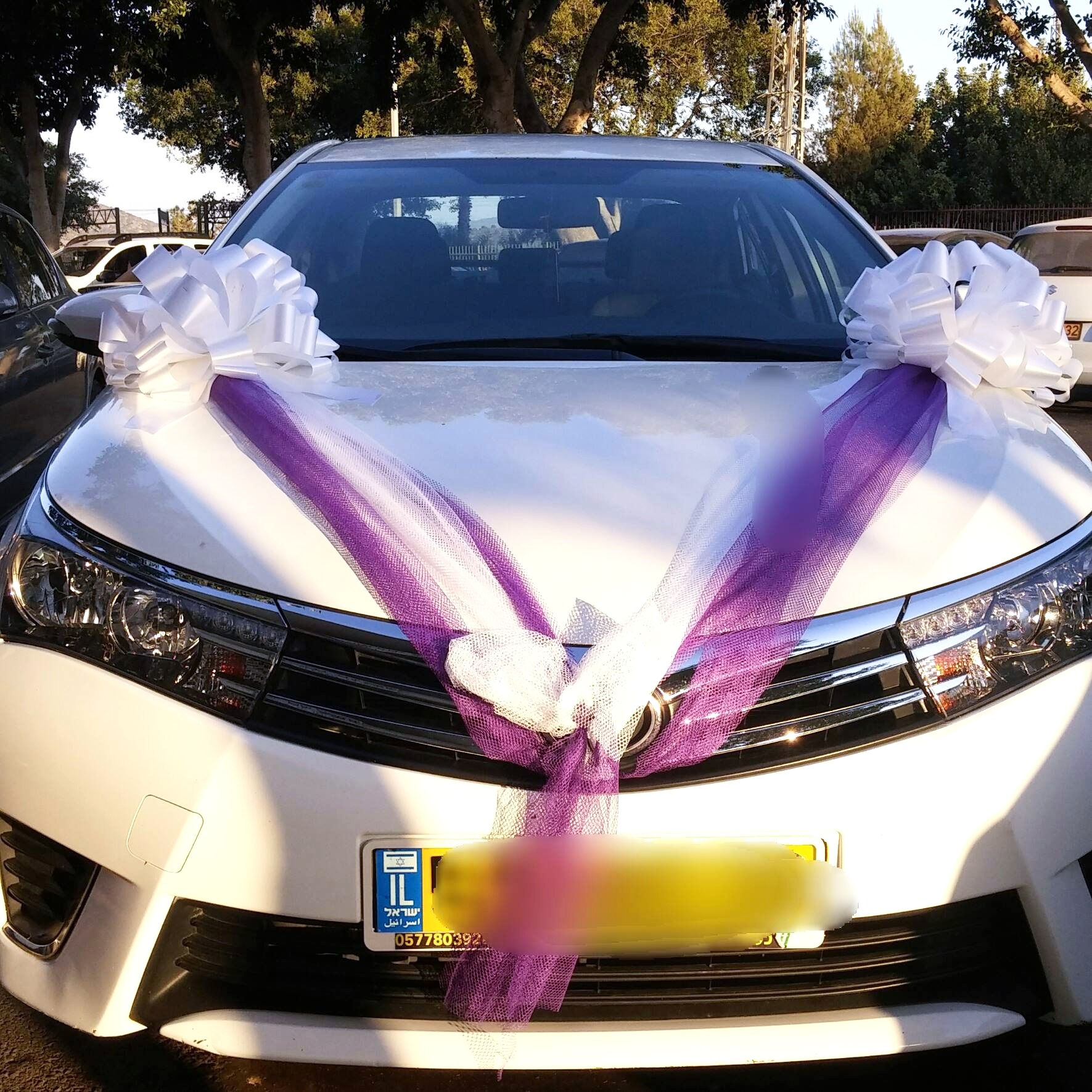 טויוטה קורולה מקושט לחתונה עם קישוט לרכב של פרחי אתי
