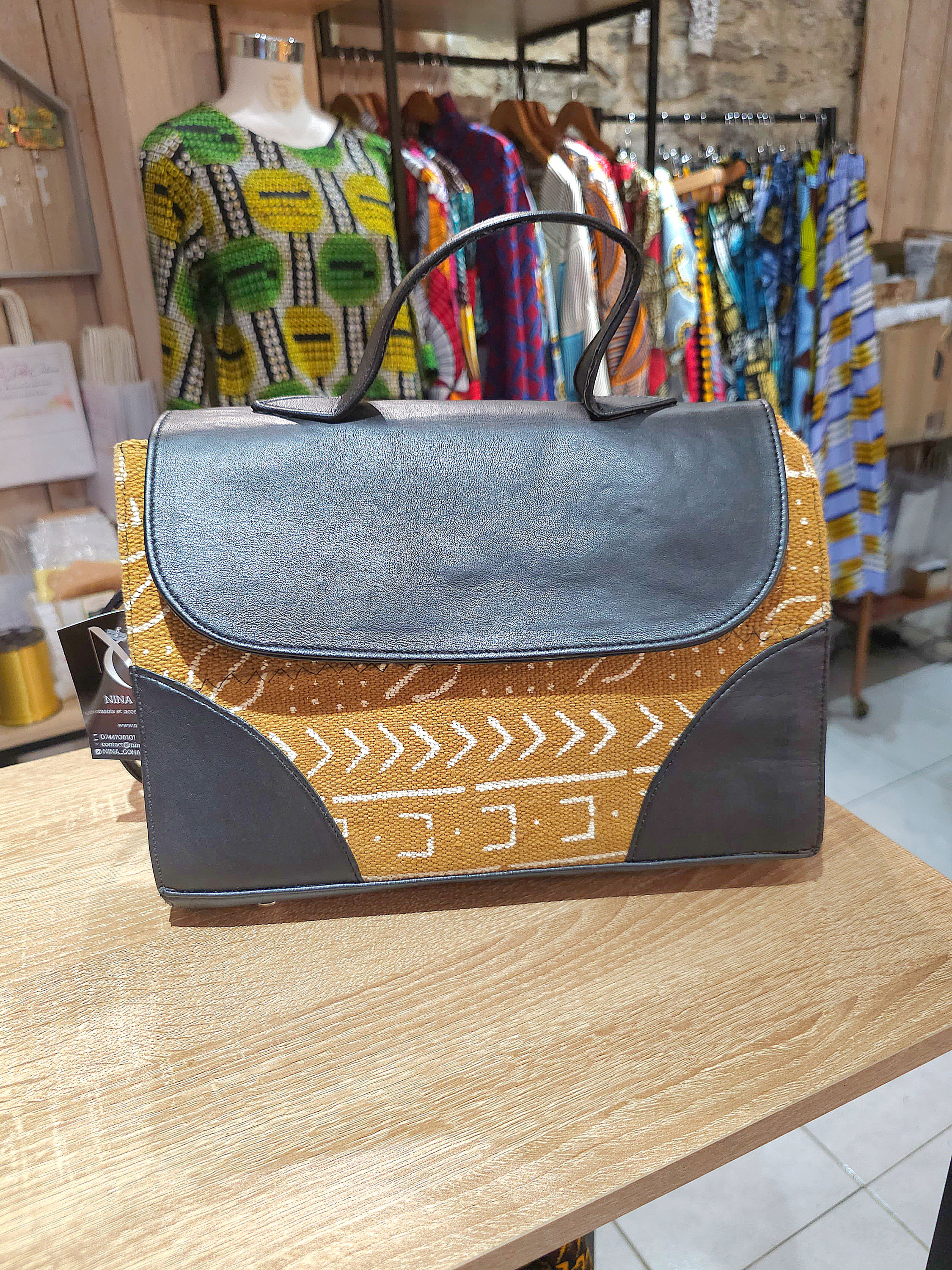 Sac à main en cuir noir et tissu africain ocre créé artisanalement par Nina Goha.