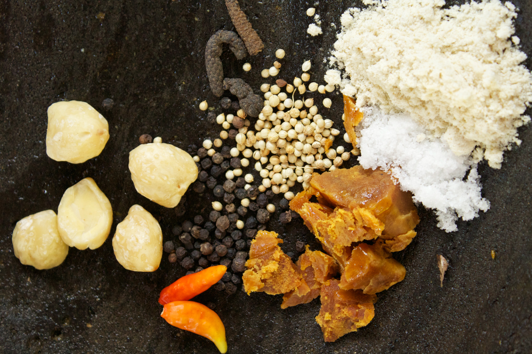 Spices and other cooking ingredients on a dark surface in West Bali’s food-guide photograph.