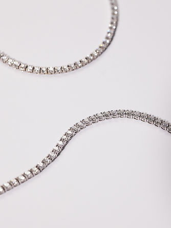 Side view close-up of handcrafted 18k white gold tennis collier with individually shaped links