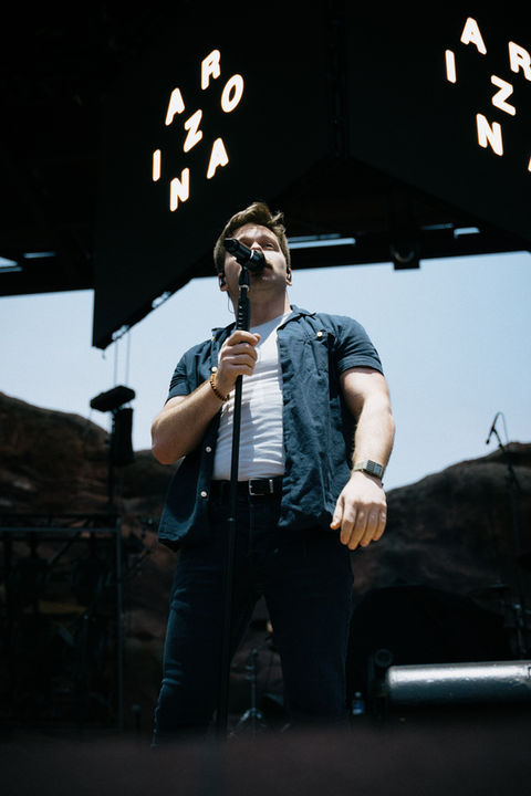 Lead singer for A R I Z O N A holding mic stand and singing to crowd at Red Rocks in Morrison, Colorado.