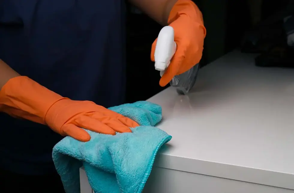 Gloved hand carefully removing fine construction dust with a microfiber cloth