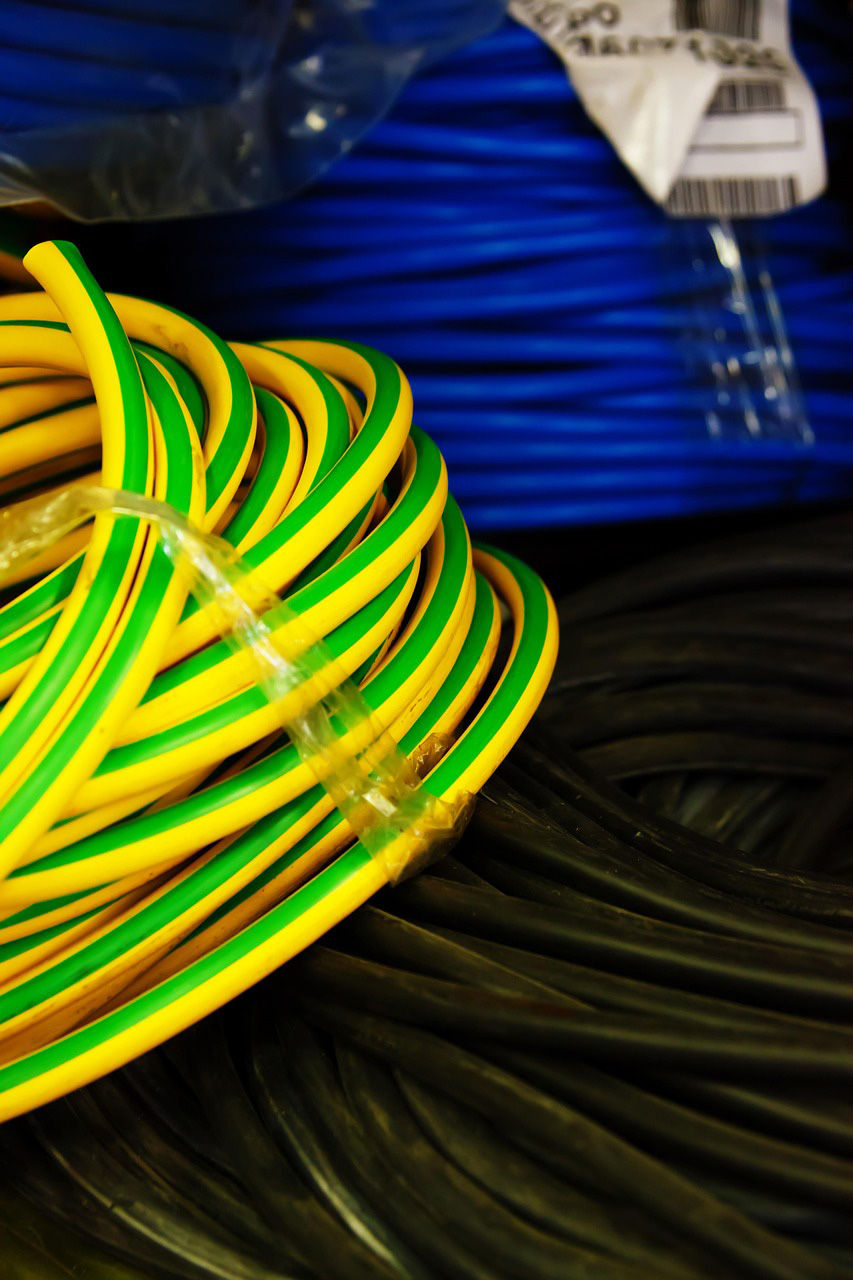 A coil of yellow and green wire with some blue and black wire in the background