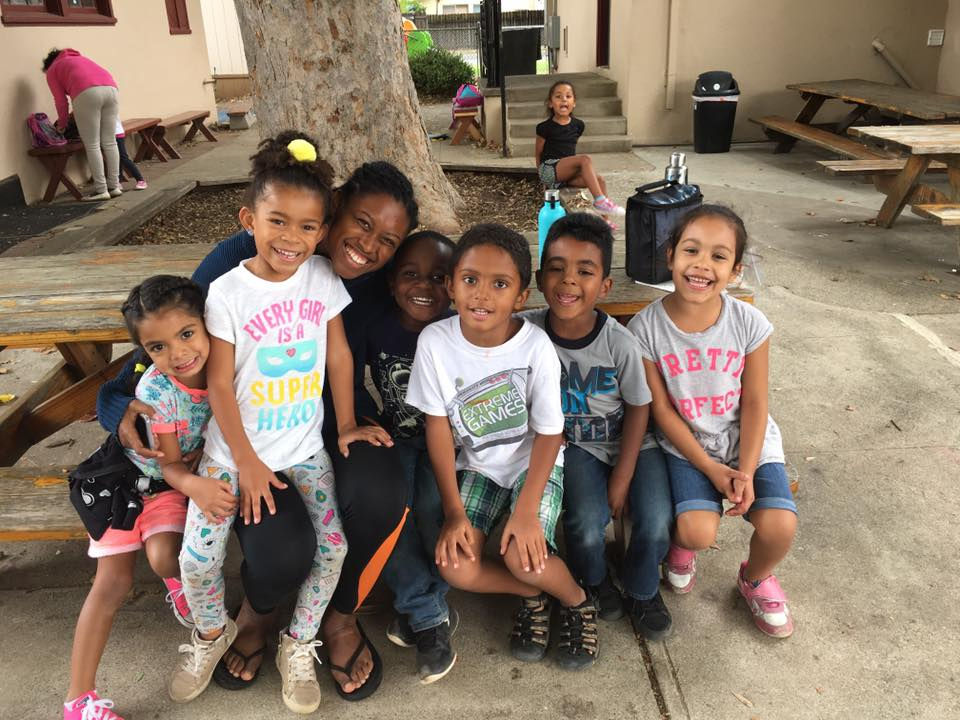 preschool children smiling with teacher