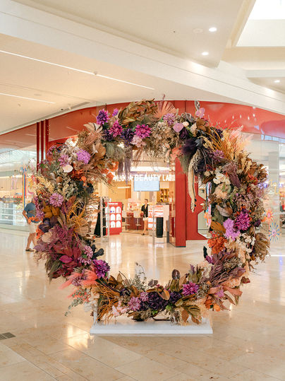Large Christmas wreath installation created by Sweet Stems for Bayfair shopping centre in Tauranga. Corporate floral styling with seasonal foliage and natural textures.