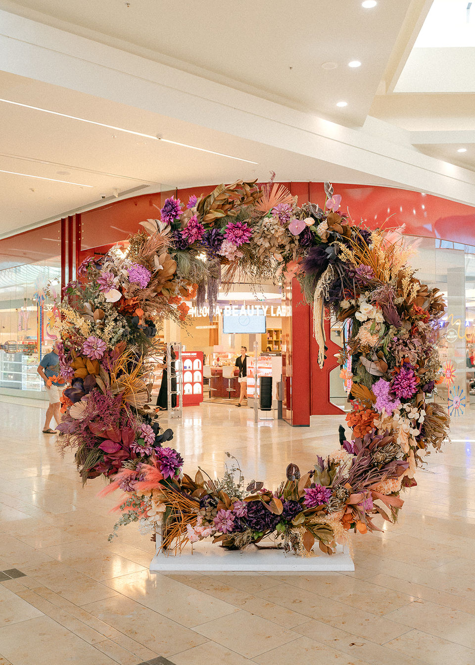 Large Christmas wreath installation created by Sweet Stems for Bayfair shopping centre in Tauranga. Corporate floral styling with seasonal foliage and natural textures.