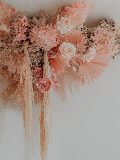 Close-up of floral wall installation created by Sweet Stems for Blush Injectables. Corporate floral styling designed to complement the business branding and interior space.