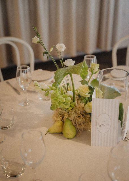 Close-up of wedding table styling with flowers, moss and green pears by Sweet Stems, Bay of Plenty wedding florist.