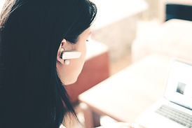 view of a woman with a blue tooth earpiece doing web design