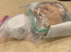 Freezer baggies with sandwich inside and a glass container with lunch