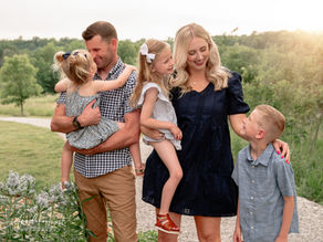 A family of 5 poses at a park in summer for their photo session