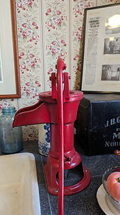 A n outdoor red hand pump for water