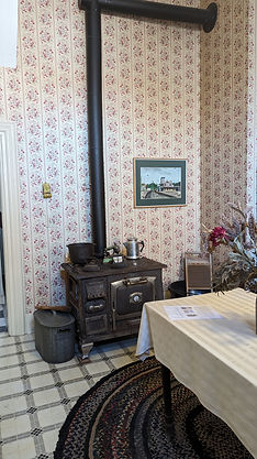 The corner of the kitchen with stove and table and wallpaper