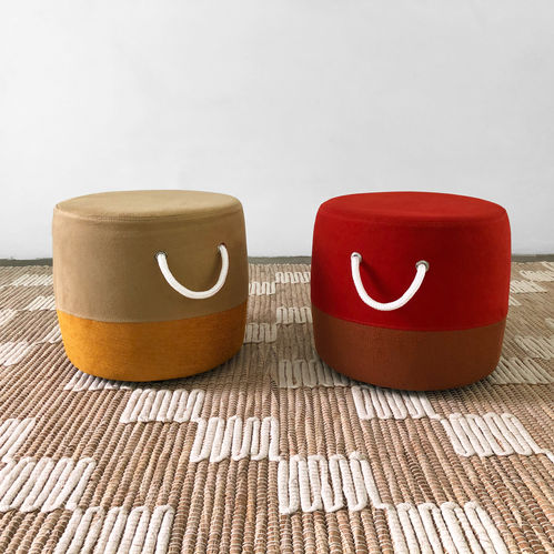 Dois Puffs Nonna em veludo bege com base mostarda e vermelho com base terracota, com alças de corda branca, sobre tapete trançado