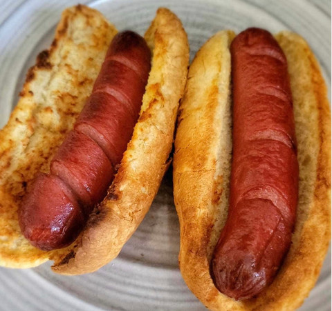 Two grilled hot dogs in buns