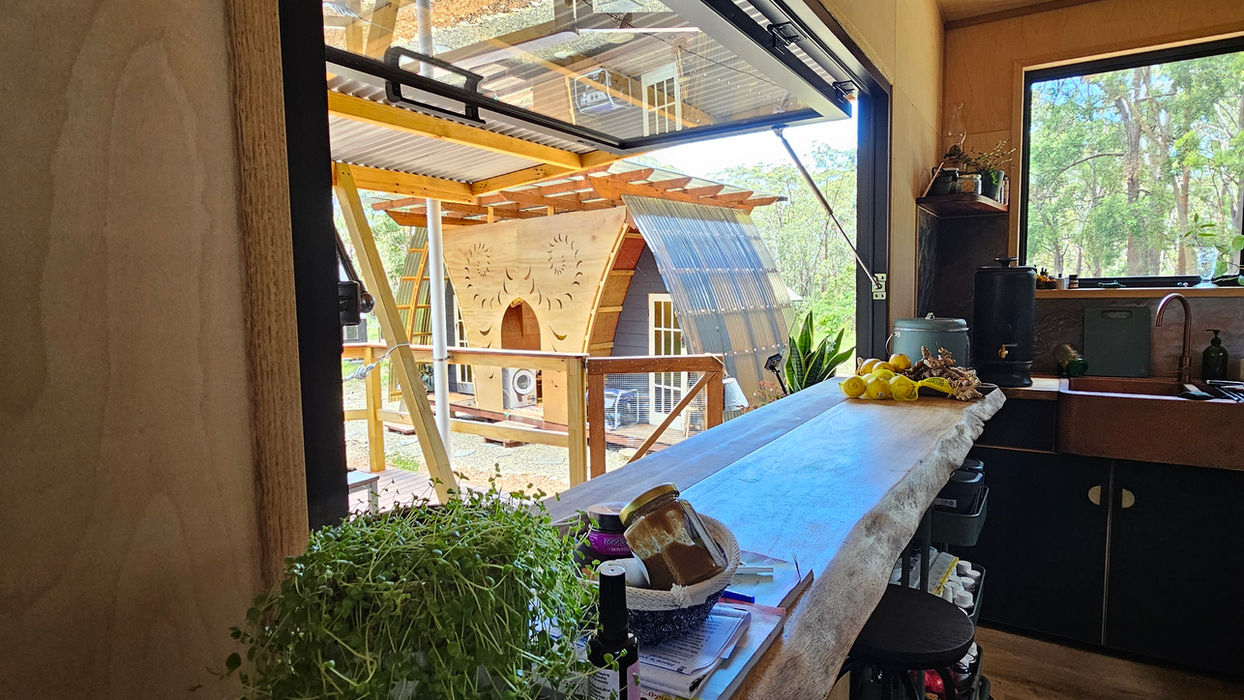 Tiny home kitchen with space-saving storage and timber detailing