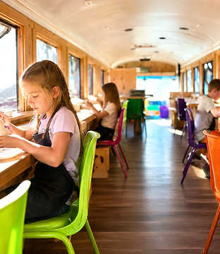 Enfants peignant une pièce de céramique dans notre autobus-atelier à la Ferme Éco des Champs à Gatineau