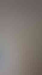 Cream colored curtains hanging, partially revealing an outdoor living area.