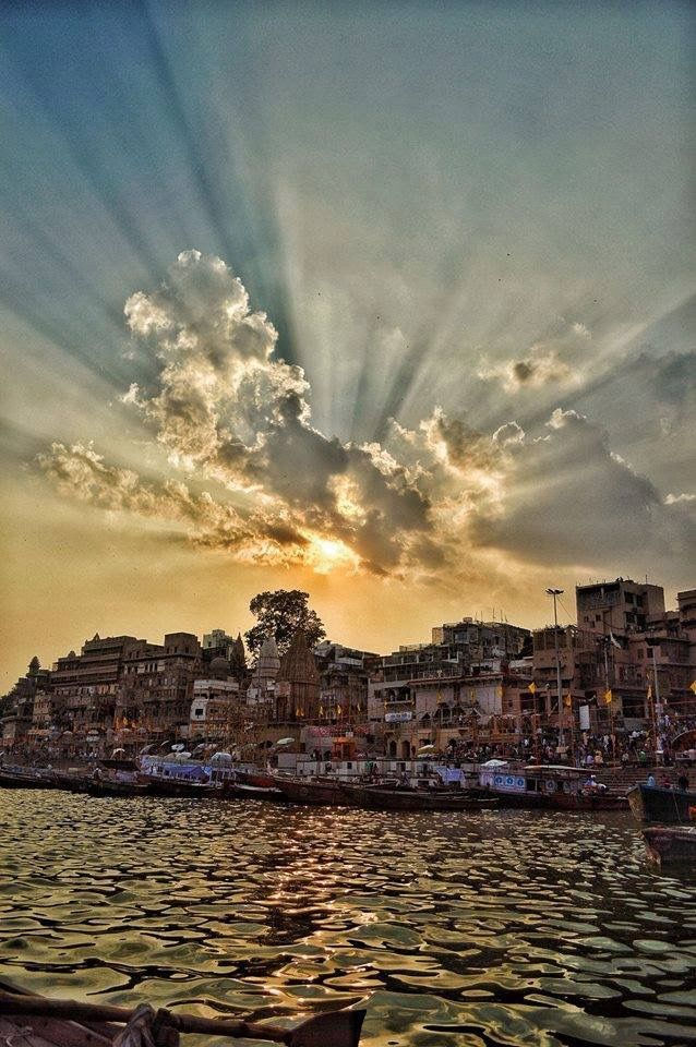 Sun rays through clouds over Banaras city and river