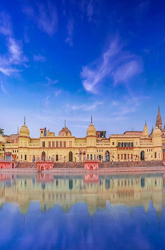 Ornate temple in Ayodhya reflected in blue water