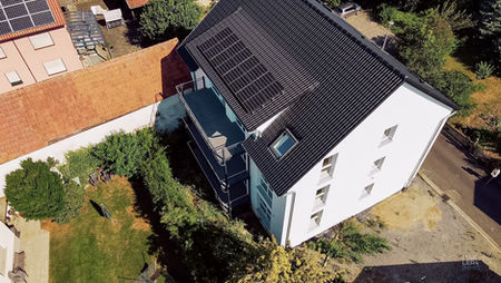 Luftaufnahme des kernsanierten Dreifamilienhauses in Oerlenbach mit dunklem Dach und Photovoltaikanlage