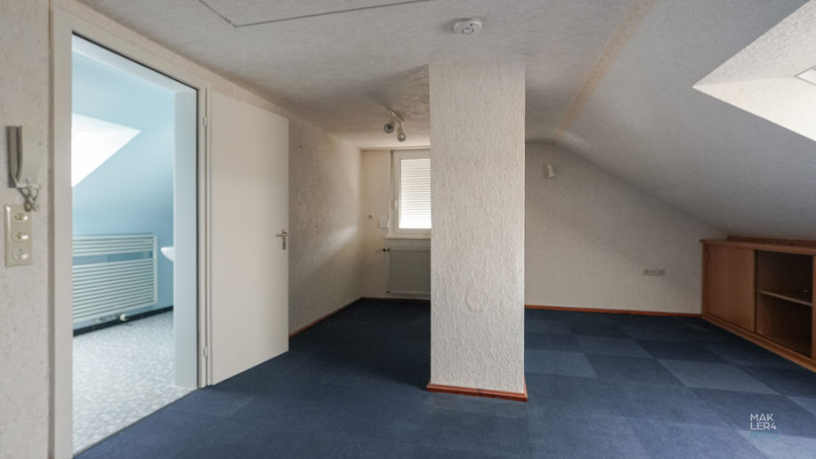 Dachgeschossraum mit Dachfenster und Zugang zum Badezimmer