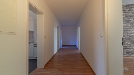 Flur mit Holzoptikboden und Zugang zu mehreren Räumen in einer Wohnung in Schweinfurt