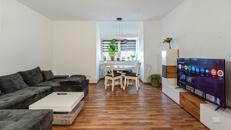 Großzügiges Wohnzimmer mit Essbereich am Fenster und Holzboden in der Mansardwohnung
