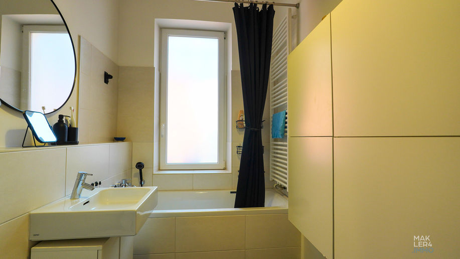Badezimmer mit Waschbecken, Fenster und Badewanne