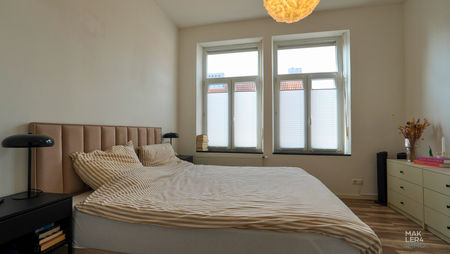 Schlafzimmer mit Doppelbett und großen Fenstern