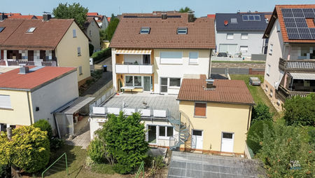Rückwärtige Ansicht des Zweifamilienhauses mit Garten und Anbau