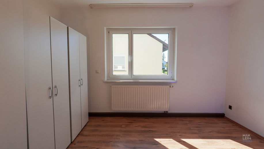 Schlafzimmer im Obergeschoss mit Einbauschrank und Fenster