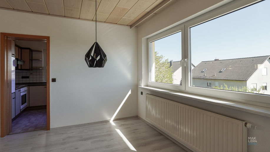 Wohnraum im Obergeschoss mit Dachschräge und Blick zur Küche
