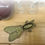Thumbnail: Decorative bronze bottle opener shaped like a bug on wooden table near glasses