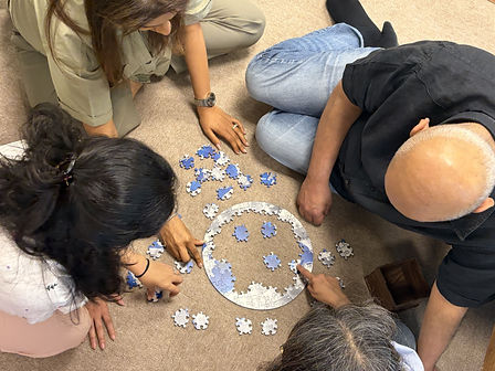 Adults collaboratively solving a CircZles circular wooden puzzle with hexagonal pieces, showcasing strategic thinking and pattern recognition.