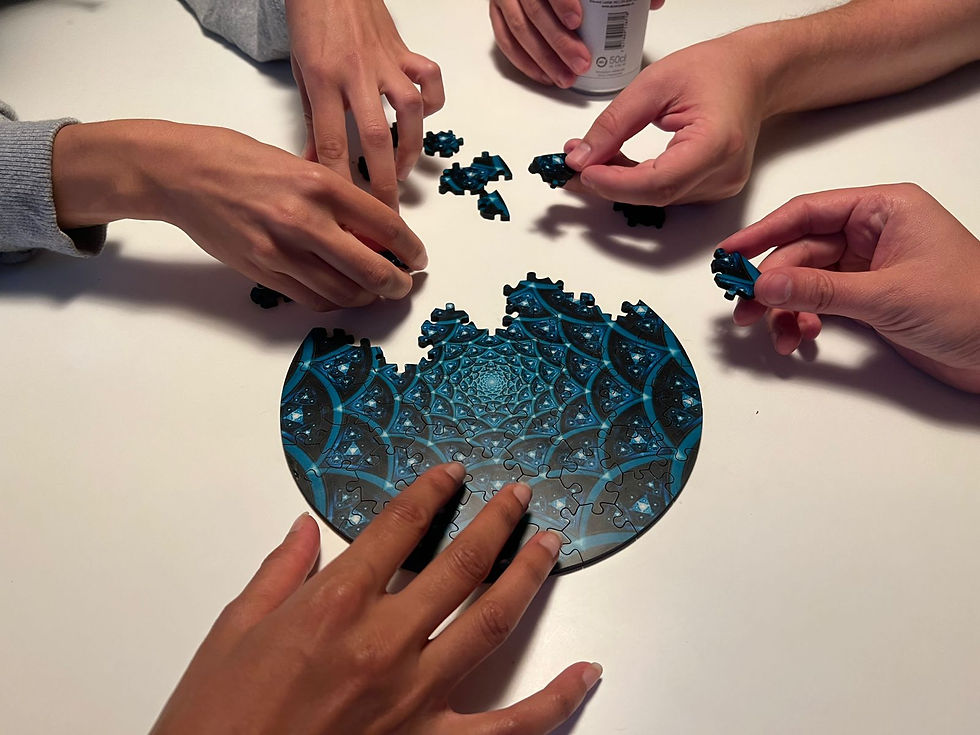 Hands assembling a blue circular jigsaw puzzle on a white table, with a can labeled 500cl in the background.
