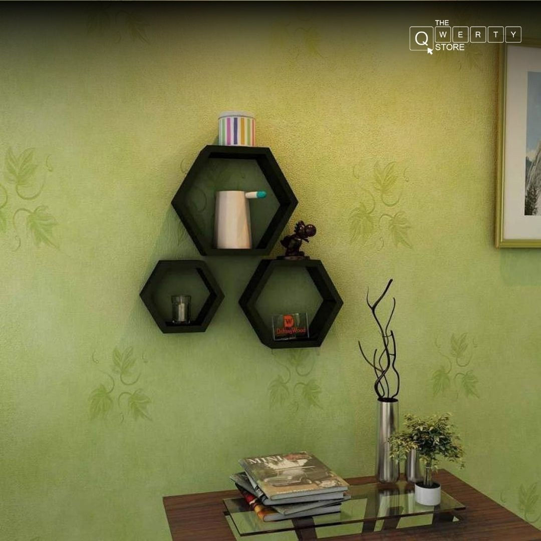 Three black hexagon shelves on green wall, holding decor, Tharmas