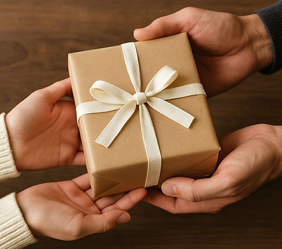 Hands giving gift wrapped in brown paper with cream ribbon present
