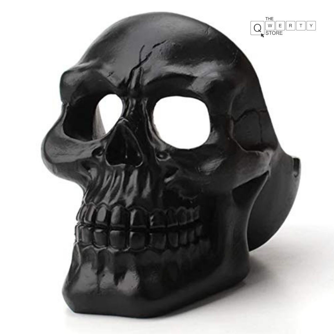 Black skull figurine with large eye sockets and jaw sitting on white