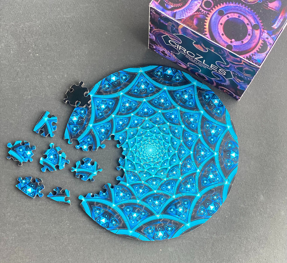 Blue circular puzzle with missing pieces on a gray table beside a Circzles box, featuring a glowing geometric pattern.