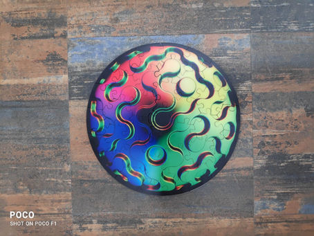 Round puzzle with vibrant swirling colors of red, green, and blue against a multicolored textured background, creating a dynamic visual.