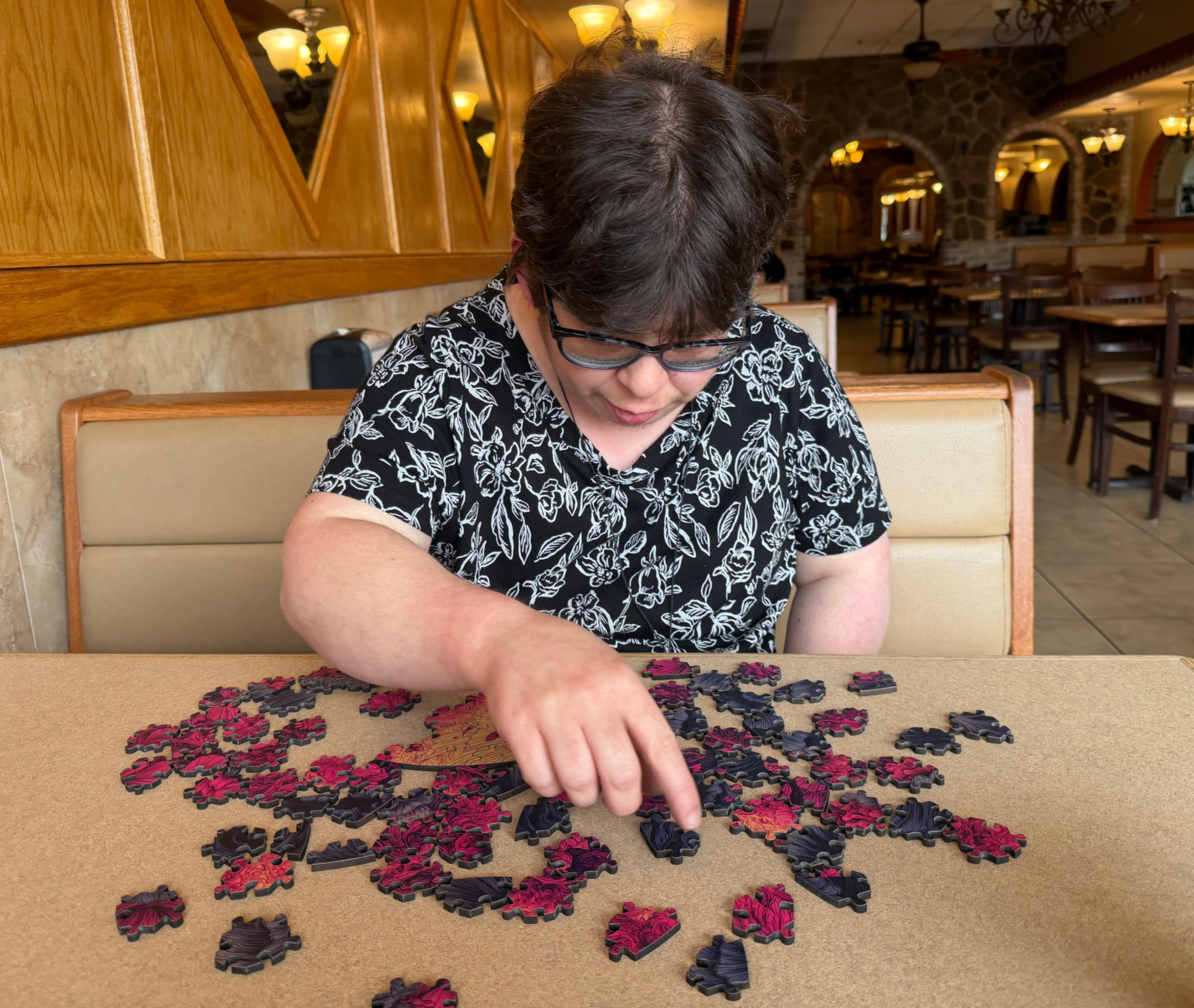 The image shows a person solving the Lucid Mandala puzzle at a table, making it an engaging choice for brain stimulating activities.