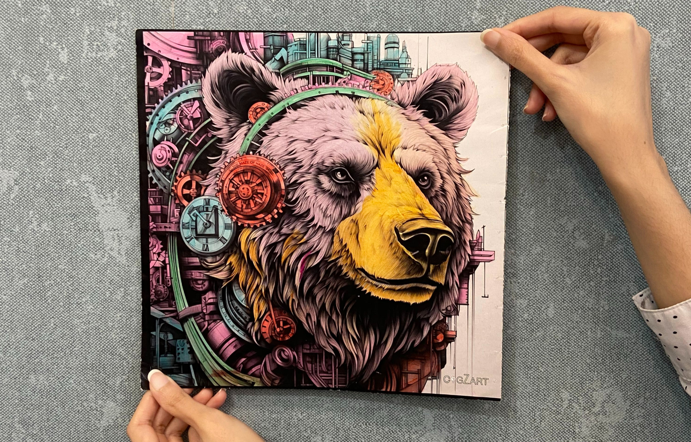 The image shows a hand holding a colorful bear illustration from the Unleash Your Inner Animal ACBs series, highlighting creative practice through expressive coloring.