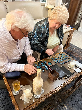 Elderly couple assembling a blue-toned circular puzzle on a coffee table, showing active mindfulness in a cozy setting.