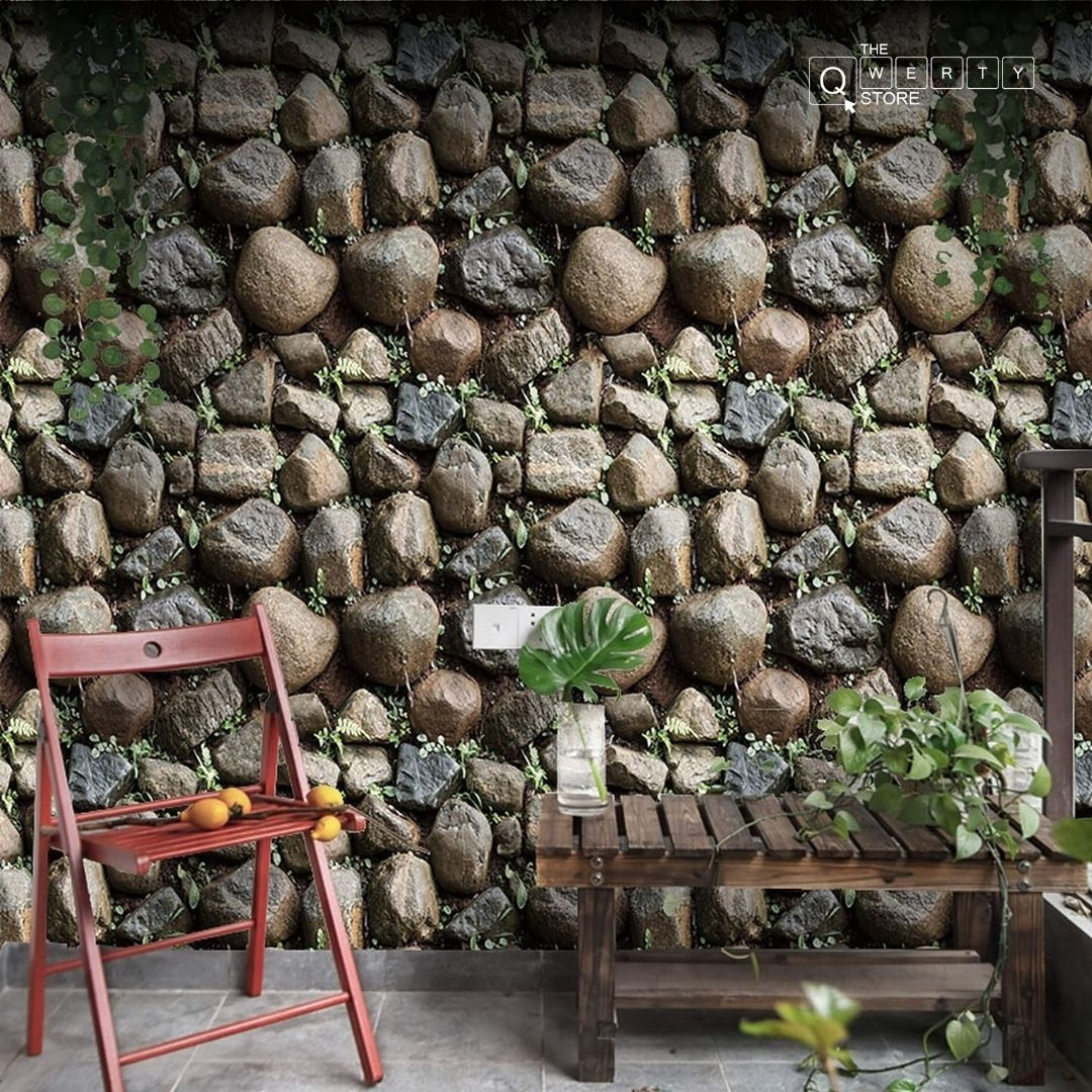 Stone wall background, red chair, wooden table, greenery, and nature setting decor.