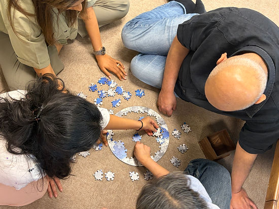 Adults enjoying a CircZles puzzle together, showing how Indoor Games for Adults can create an engaging, screen-free group activity.