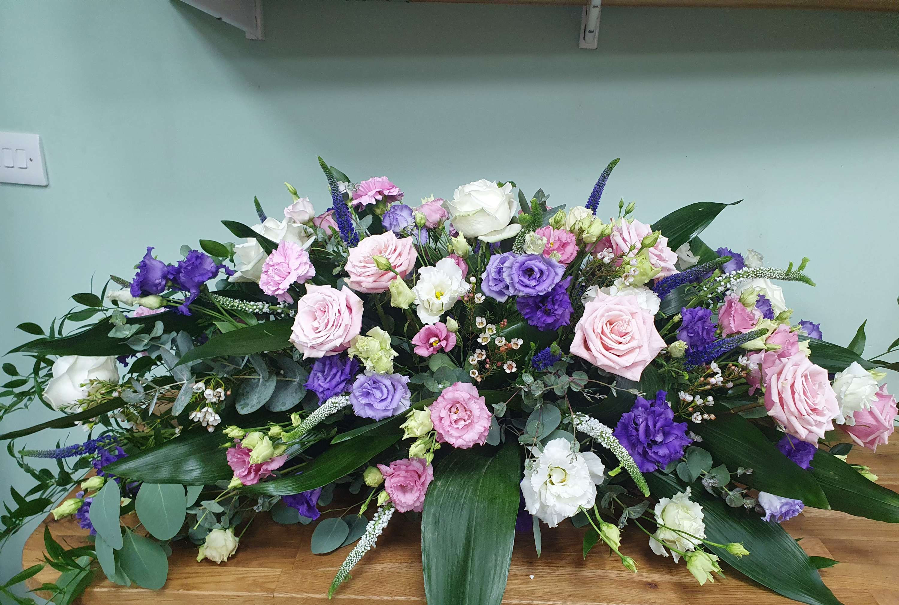Pink, white  and purple casket spray