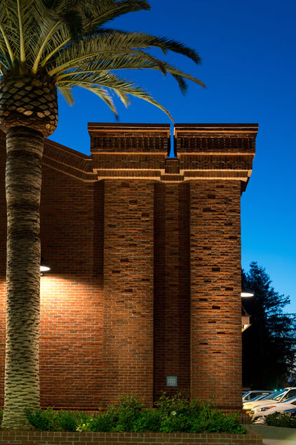 Uplit brick pilasters and projecting header courses against a deep blue night sky