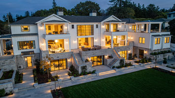 Rear facade lit at night, its lower story wrapped in Fond du Lac veneer and terraces