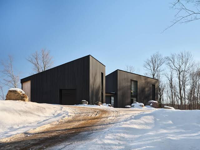 Black-clad modern home with Norwood steel siding in winter